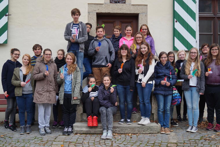 Gruppenfoto der Teilnehmer am Gruppenleiterkurs mit bunten Federn